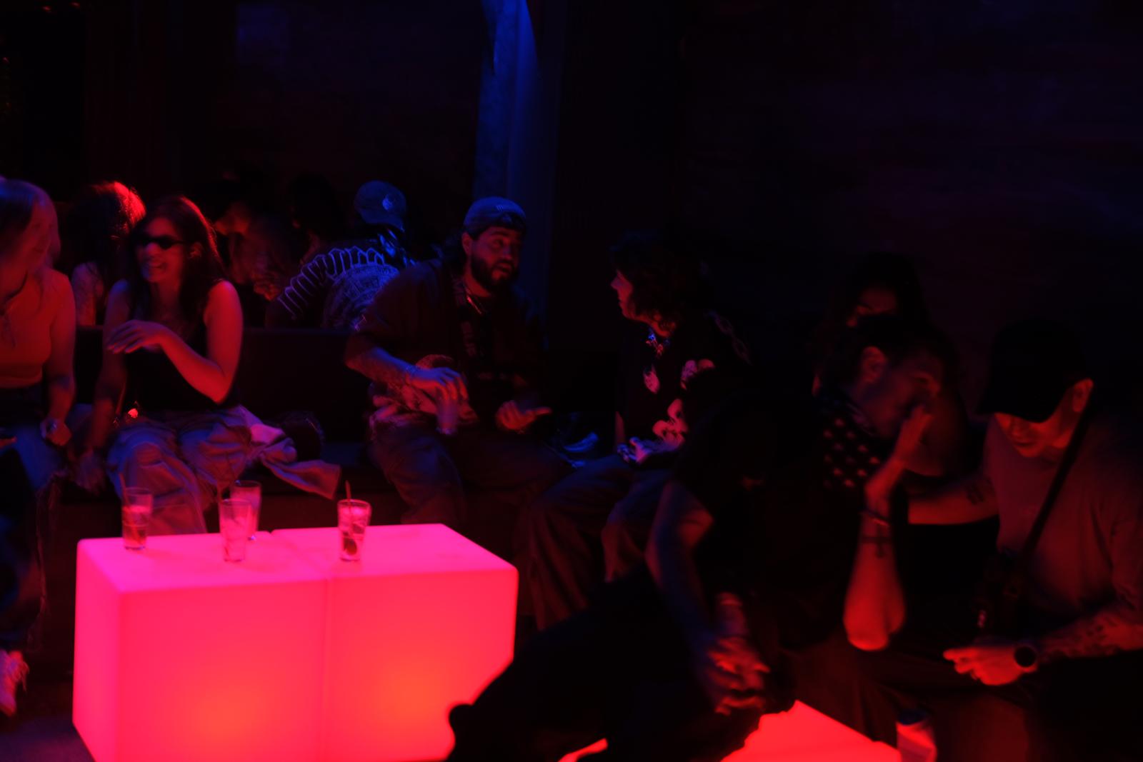 Guests at a glowing table under red light